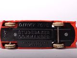 a close up of a red and black skateboard on a white surface