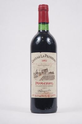une bouteille de vin rouge posée sur une table blanche