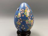 a close up of a blue egg with flowers painted on it