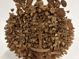 une sculpture en bois représentant un panier rempli de noix et de feuilles