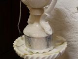 a white fountain with a bird on top of it