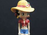 a figurine of a woman wearing a hat and holding a suitcase