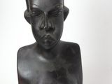 statue of a woman with a hat on her head and a vase in the background