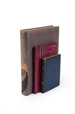 trois livres sont empilés sur une surface blanche