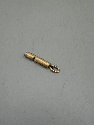 a small metal object on a white surface with a small metal object in the background