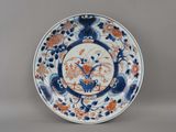 assiette bleue et blanche ornée de fleurs orange et d'oiseaux