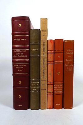 several books are stacked on top of each other on a white surface