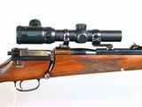 the rifle is on the table with the scope on it ' s side