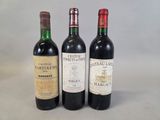 trois bouteilles de vin sont alignées sur une surface blanche