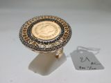 une bague en or surmontée d'une pièce de monnaie