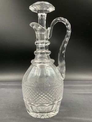 a clear glass vase with a handle on a table