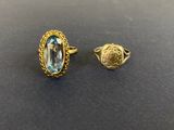une paire de bagues en or ornées d'une topaze bleue ovale
