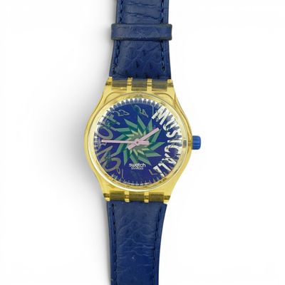 gros plan d'une montre sur une surface blanche avec un bracelet bleu
