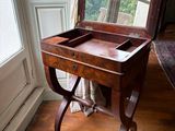 une table en bois sur laquelle est posé un miroir, devant une fenêtre