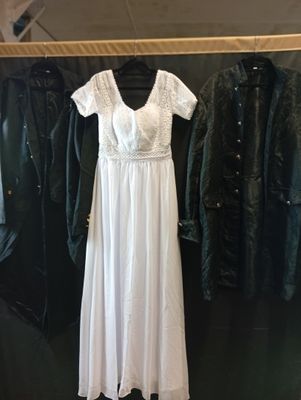 une robe blanche sur un cintre dans un magasin de vêtements