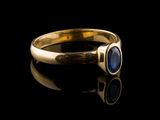 a close up of a gold ring with a blue stone