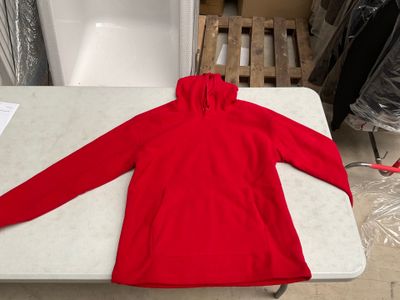 un sweat-shirt rouge posé sur une table dans une pièce