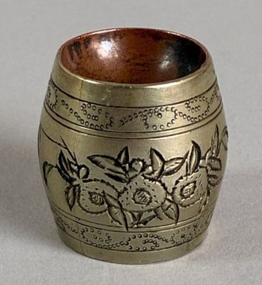 a small gold vase with a floral design on it