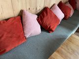 four red and pink pillows sitting on a blue couch