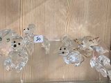 deux ours en verre posés sur une étagère en verre