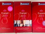 trois livres rouges sont empilés les uns sur les autres sur une table