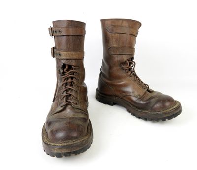 une paire de bottes en cuir marron à lacets sur fond blanc