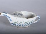 a small blue and white bird shaped bowl on a table