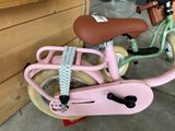 a pink bicycle with a basket on the back of it