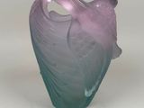 un vase violet et bleu posé sur une surface blanche