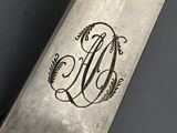 a knife with a monogram on it sitting on a table