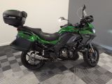 a green motorcycle parked in a room with a checkered floor