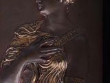 sculpture of a woman holding a bird in her right hand