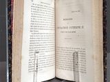 an open book on a table with a candle on it