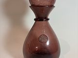 a brown glass vase sitting on a white surface