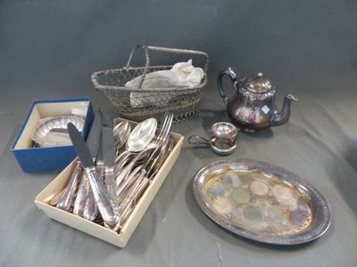des couverts et de l'argenterie sur une table, avec un panier contenant des couverts