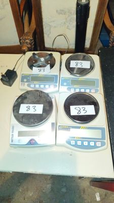 trois balances électroniques posées les unes à côté des autres sur une table