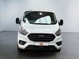 the front of a white ford transit van parked in a showroom