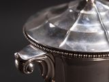 a silver bowl with a lid on a table