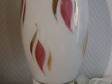 a white vase with a red and gold design on it