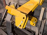 a yellow machine that is sitting on a pallet next to a brick wall