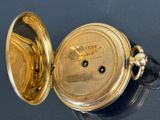 a close up of a gold pocket watch on a table