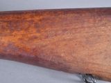 an old rifle with a wooden barrel on a gray surface