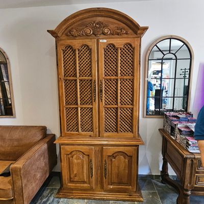 un homme debout devant une armoire en bois dans un salon