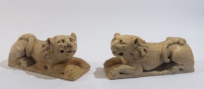 une paire de lions sculptés dans la pierre sur fond blanc