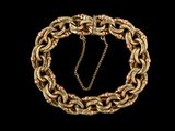gros plan d'un bracelet en chaîne en or sur fond noir
