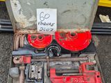une boîte à outils posée par terre à côté d'une boîte sur laquelle est accrochée une pancarte