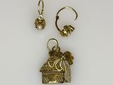two gold earrings and a ring with a bird on it