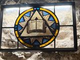 a stained glass window with an open book on it