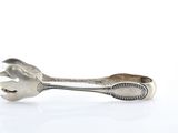 a silver spoon and a wrench on a white surface