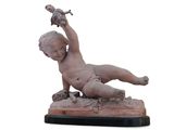 une statue représentant un garçon allongé par terre, avec un oiseau posé sur son bras